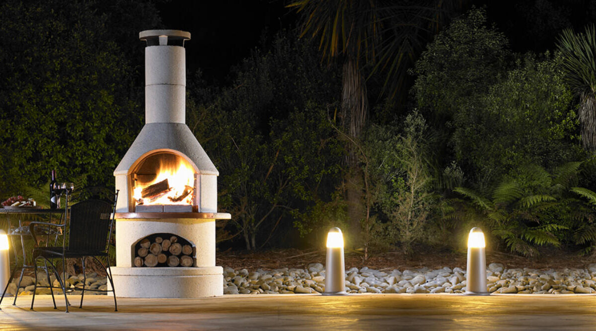Buschbeck outdoor fireplace lit on a dark winter evening.