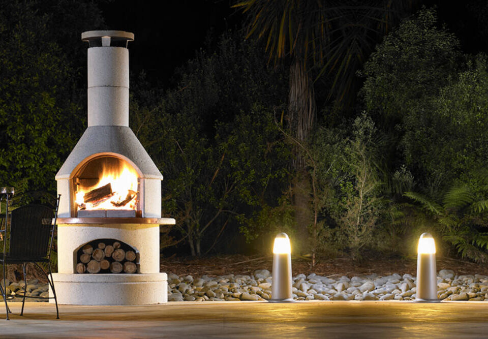 Buschbeck outdoor fireplace lit on a dark winter evening.